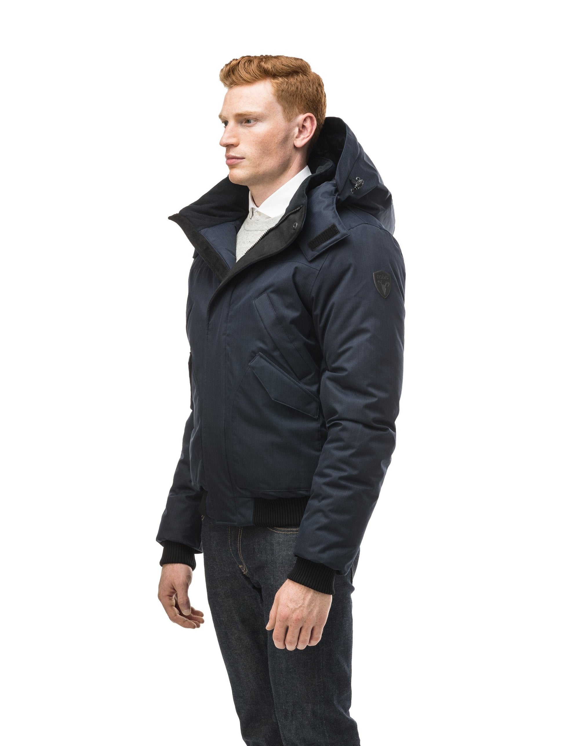 Men's classic down filled bomber jacket with a down filled hood that features a removable coyote fur trim and concealed moldable framing wire in Navy