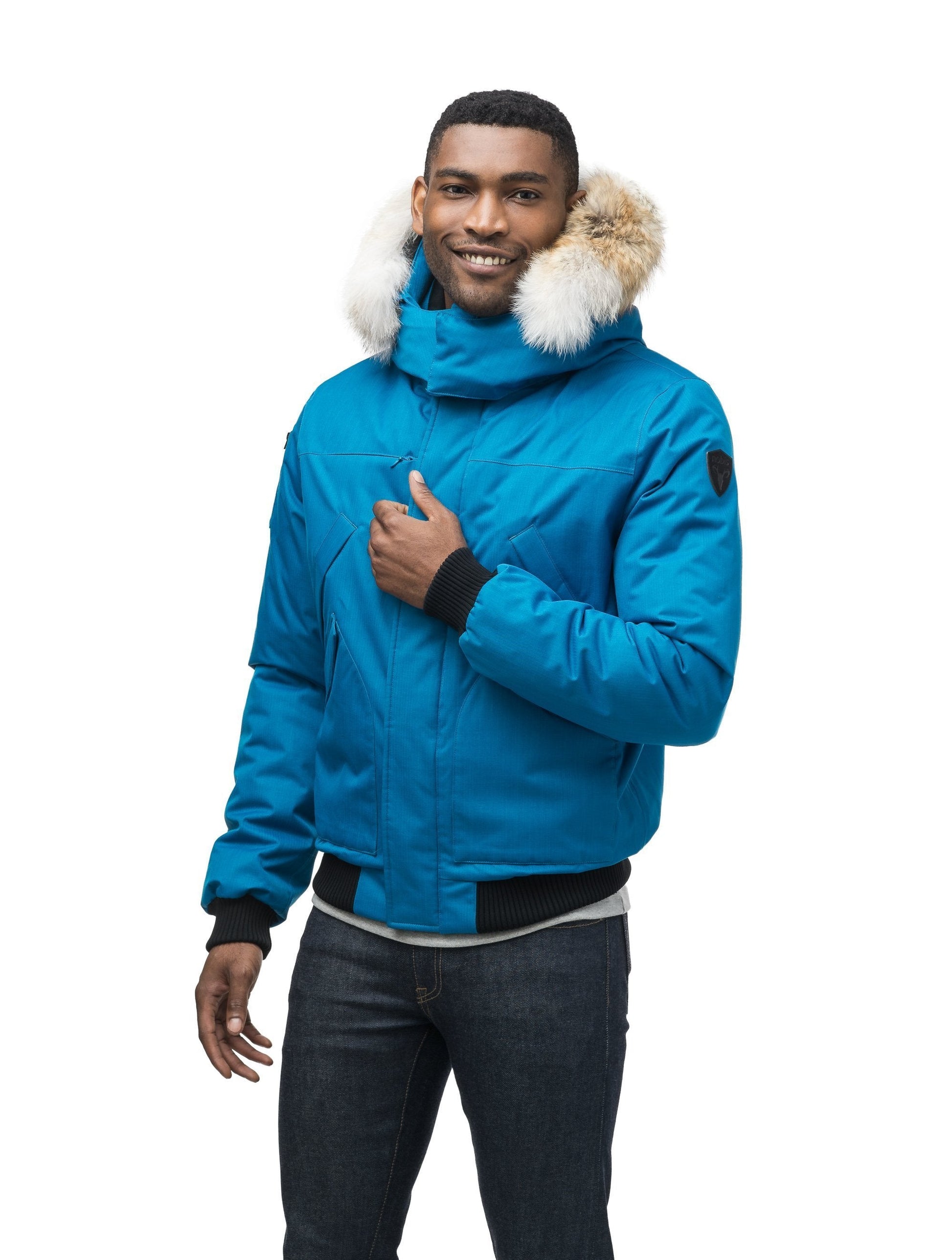 Men's classic down filled bomber jacket with a down filled hood that features a removable coyote fur trim and concealed moldable framing wire in Sea Blue