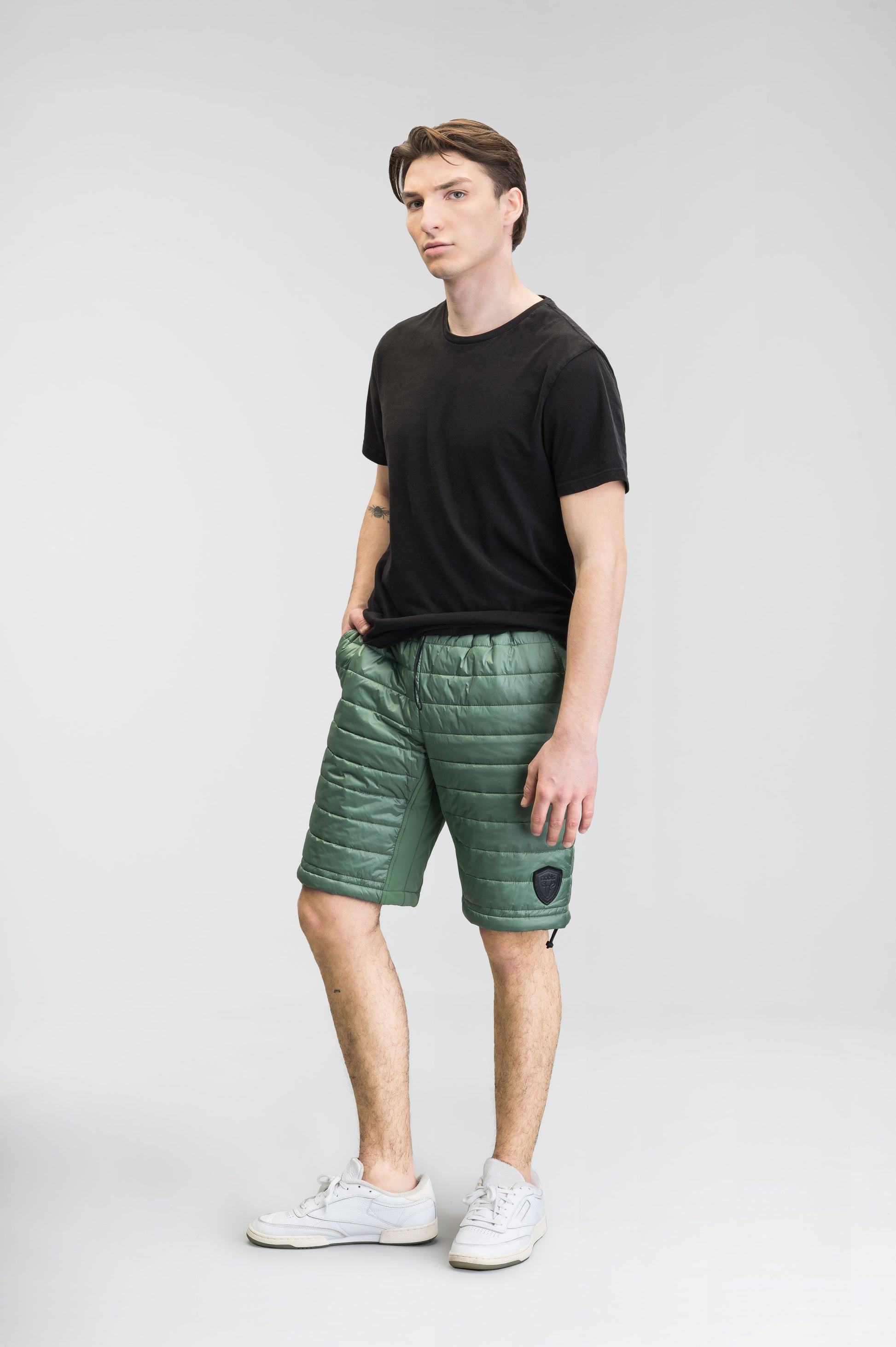 Decker Men's Performance Quilted Shorts in knee length, premium cire technical nylon taffeta and stretch nylon fabrication, premium 4-way stretch, water-resistant Primaloft Gold Insulation Active+, side seam pockets, invisible zipper back pokcet, elasticized waist with drawcords, and hidden drawcord at leg hems, in Comfrey