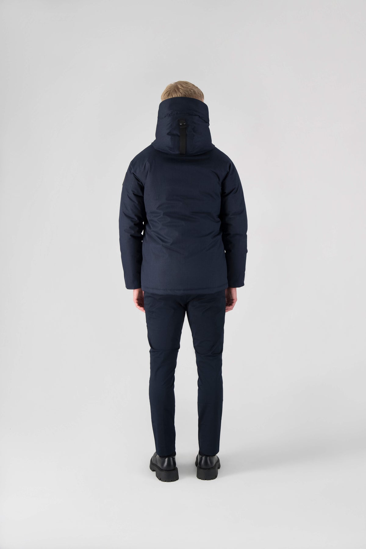 Men's waist length down filled jacket with two front pockets with magnetic closure and a removable fur trim on the hood in Navy