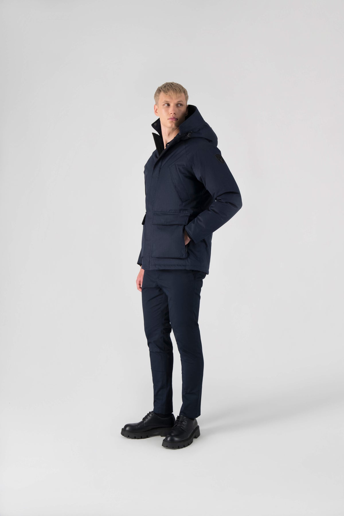 Men's waist length down filled jacket with two front pockets with magnetic closure and a removable fur trim on the hood in Navy