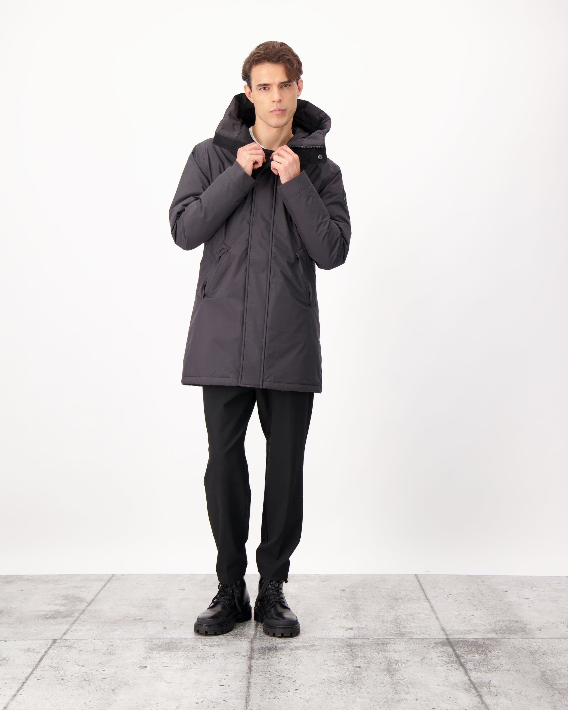 Pierre Men's Jacket in thigh length, Canadian white duck down insulation, non-removable down-filled hood, angled waist pockets, centre-front zipper with wind flap, and elastic ribbed cuffs, in 3L Black