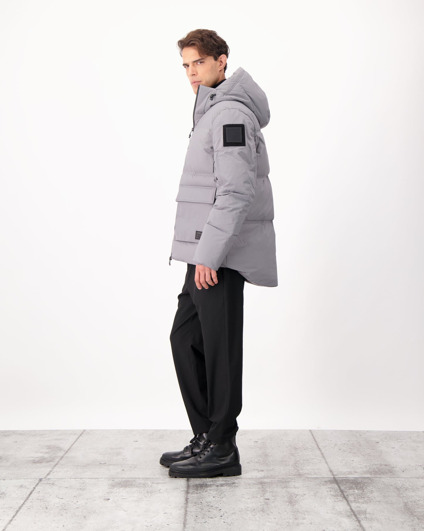 Supra Men's Performance Puffer in hip length, Technical Taffeta and 3-Ply Micro Denier fabrication, Premium Canadian White Duck Down insulation, non-removable down filled hood, centre front two-way zipper, flap pockets at waist, and zipper pocket at left bicep, in Concrete
