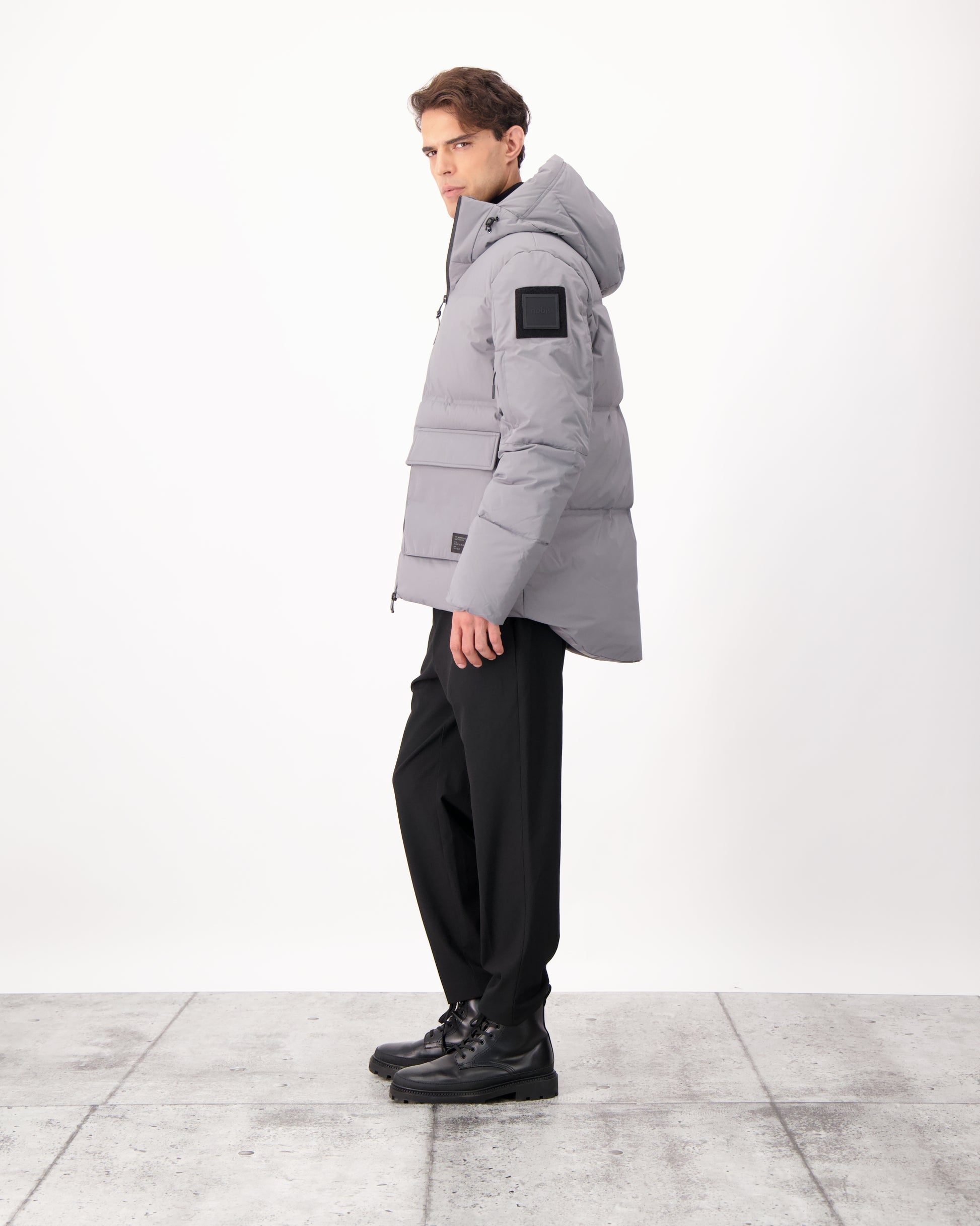 Supra Men's Performance Puffer in hip length, Technical Taffeta and 3-Ply Micro Denier fabrication, Premium Canadian White Duck Down insulation, non-removable down filled hood, centre front two-way zipper, flap pockets at waist, and zipper pocket at left bicep, in Concrete