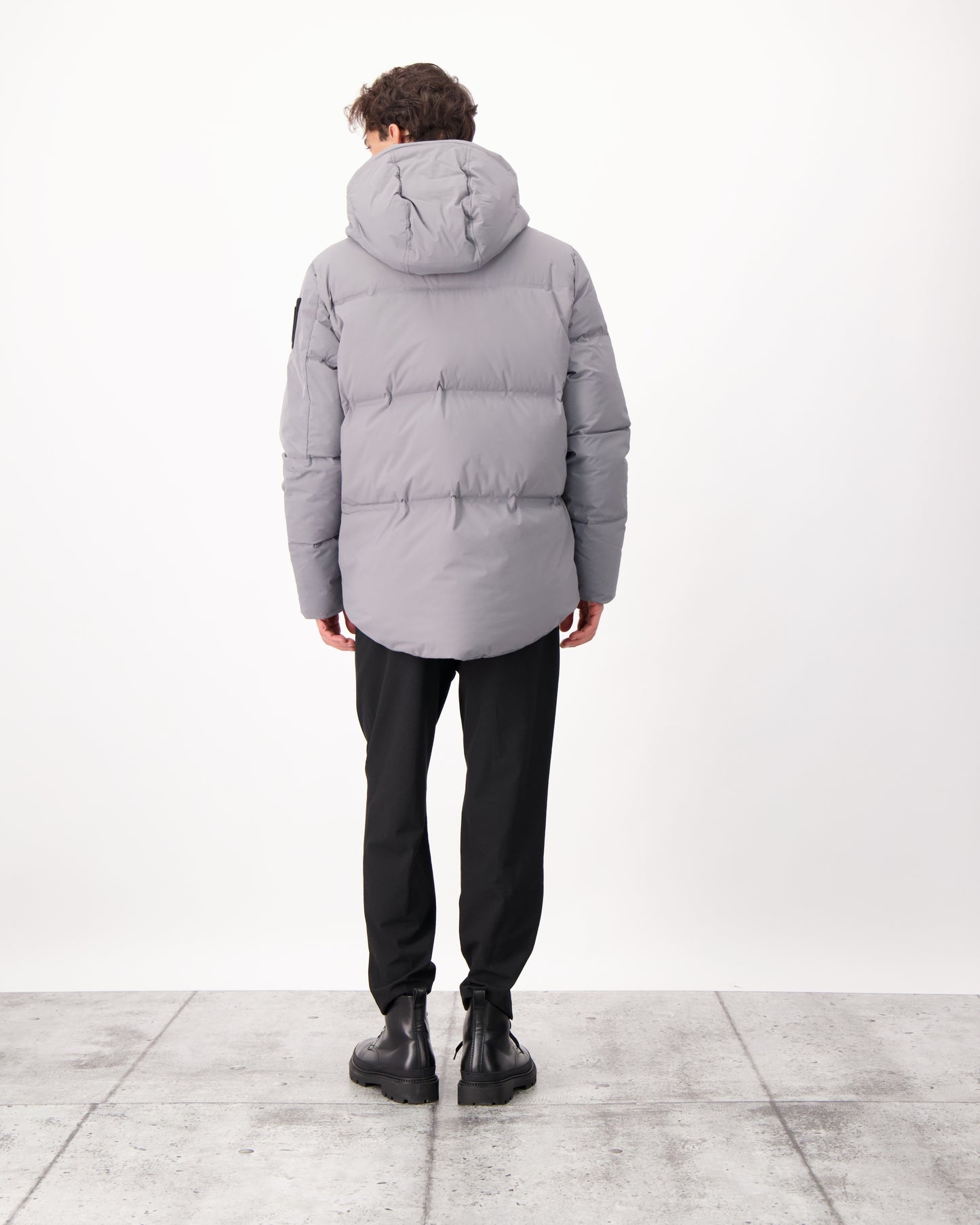 Supra Men's Performance Puffer in hip length, Technical Taffeta and 3-Ply Micro Denier fabrication, Premium Canadian White Duck Down insulation, non-removable down filled hood, centre front two-way zipper, flap pockets at waist, and zipper pocket at left bicep, in Concrete