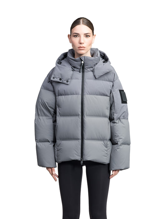 Una Ladies Performance Puffer in hip length, Technical Taffeta and Durable Stretch Ripstop fabrication, Premium Canadian White Duck Down insulation, removable down filled hood, centre front two-way zipper, and side-entry pockets at waist, in Concrete